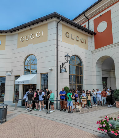 Milan, Italy - 07 06 2023: People waiting outside Gucci store in outlet. Queue of people at the storeのeditorial素材