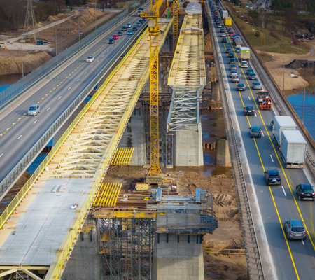 Highway road construction site. Aerial drone top view of road currently under construction. Building...