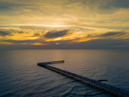 Colorful sunset and Palanga resort pedestrian bridge, pier. Aerial drone photo of summer sunset horizon view over Baltic sea, Lithuaniaの写真素材