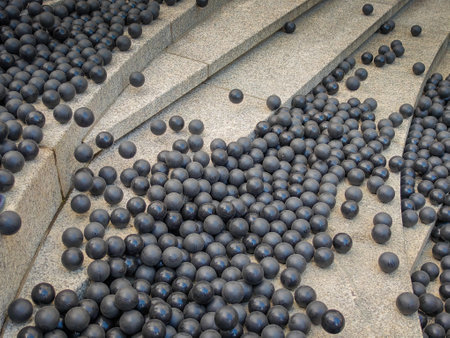 Hundreds or thousands of black rubber balls laying on the stone stairs in the street. Part of public street performanceの写真素材