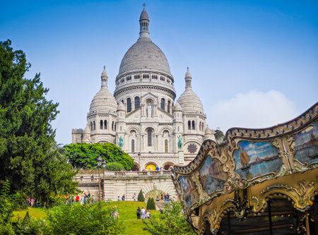 Fragment of colourful carousel with Basilique Du Sacre Coeur de Montmartre. Close up photo of Sacred heart iconic white-domed church in Paris, Franceの写真素材