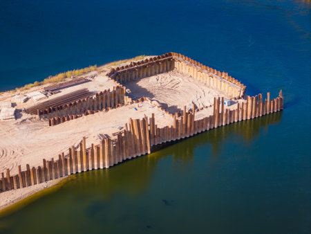 Construction site of new modern bridge construction in Kaunas, Lithuania. Aerial drone view of bridge connecting two shores of a river. Work progressの写真素材