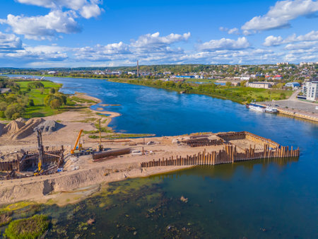 Construction site of new modern bridge construction in Kaunas, Lithuania. Aerial drone view of bridge connecting two shores of a river. Work progressの写真素材