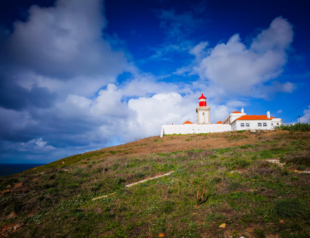 Cabo da Roca, the westernmost point of the continental Europe in Portugal. Picturesque view of a lighthouse on the rock on a sunny dayの写真素材