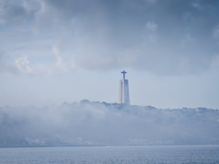 Cristo Rei Statue in the fog near Tagus river. Sanctuary of Christ the King on a cloudy dayの写真素材
