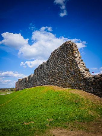 Castle defensive stone wall ruins in Medininkai, Lithuania with a blue sky backgroundの写真素材