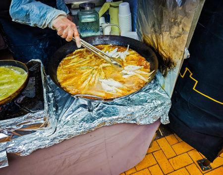 Smelt fish fried in a large round frying pan during a Stintu festival in Palanga, Lithuania. Crispy breaded european smelt fish in oilの写真素材