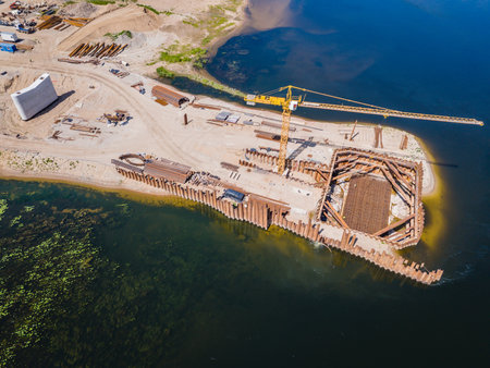 Construction site of new modern bridge construction in Kaunas, Lithuania. Aerial drone view of bridge connecting two shores of a river. Work progressの写真素材