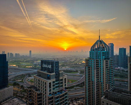 12 02 2025 - Dubai, UAE. Sunset over Dubai skyline, skyscrapers in warm evening light, urban landscape. Aerial drone view of golden hourのeditorial素材