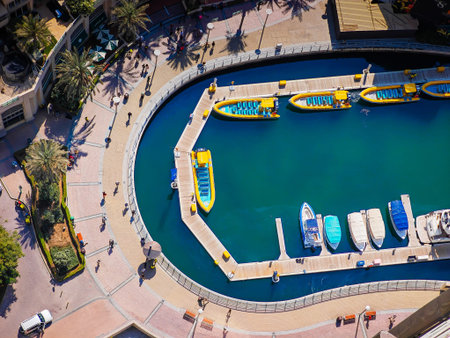 Aerial drone view of Dubai Marina harbor with many luxury yachts, capturing modern waterfront and...