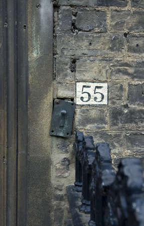 the number 55 painted on old Cambridge wall with doorbellの写真素材