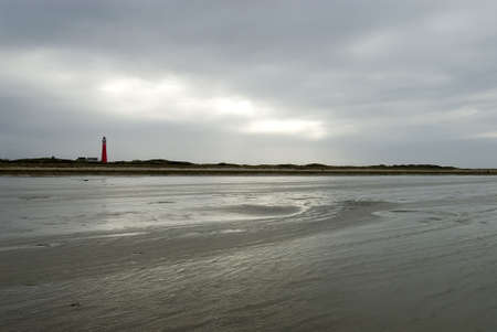 a cloudy winterday on Schiermonnikoog beach showing the lighthouseの写真素材