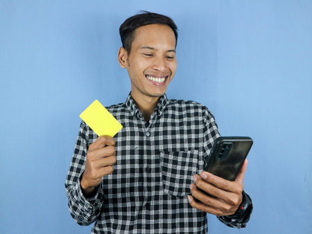 Happy expression handsome asian man hold paper money banknotes and empty card. Business and finance...