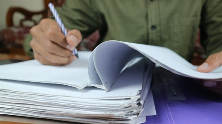 Businessman Preparing reports papers. Piles of unfinished document achieves with paper clip. Concept...