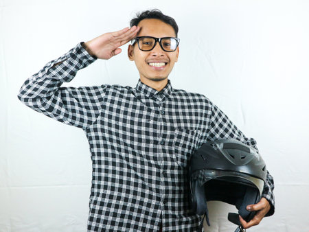 Portrait Asian man holding motorcycle helmet with excited expression. Safety riding.の写真素材
