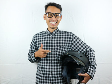 Portrait Asian man holding motorcycle helmet with excited expression. Safety riding.