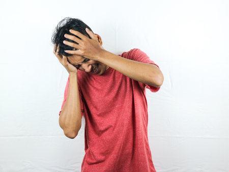 Asian people are upset and squeezing their heads with hands from a headache. The concept of stress and migraine.の写真素材