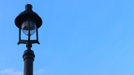 street lighting lights on city sidewalk with blue sky background.