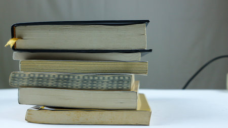 stacks of old books on a wooden table in an old library. Old books historical background. Retro...