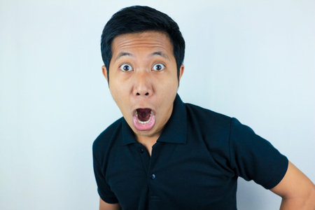funny expression of shocked and surprised Asian man isolated on white background