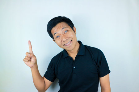 Asian man expression smiling while pointing to the side.