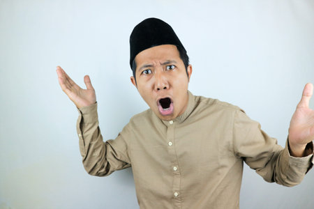 funny facial expression shock and confuse asian muslim men wearing cap isolated on white background
