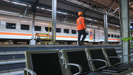 Semarang 17 April 2024 : a train officer is controlling the tracks at an Indonesian railway stationの写真素材