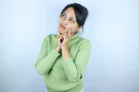 Young asian woman standing pose thinking on isolated white background. copy space for text advertise