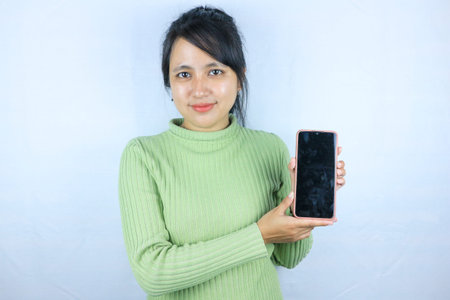 Young beautiful asian woman holding blank screen smart phone on white background