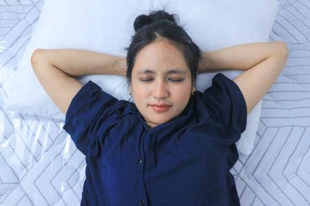 Beautiful asian woman sleep and sweet dream lying on bed in cozy bedroom in the morning feeling so relax and comfortableの写真素材