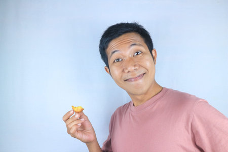 Funny expression of young asian man holding food, isolated on white background