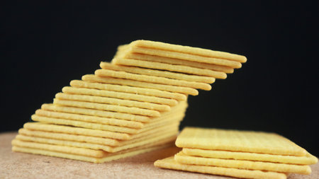 Stack of salted biscuits crackers on black background