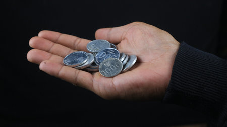 Close up of male hands holding Indonesian coins, savings and banking concept