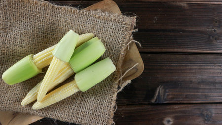 Top view baby corn on wooden table with copy space. Cooking conceptの写真素材
