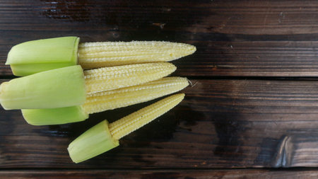 Top view stack of baby corn on wooden table with copy space for text.の写真素材