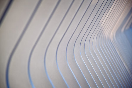 Abstract receding diagonal pattern of a curved metal railing with selective focus in a full frame...