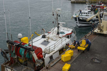 SEPTEMBER 2021 - GUILVINEC - FRANCE: view on fisherman unloading their fish on the harbor of the guivilnec in Brittanyのeditorial素材