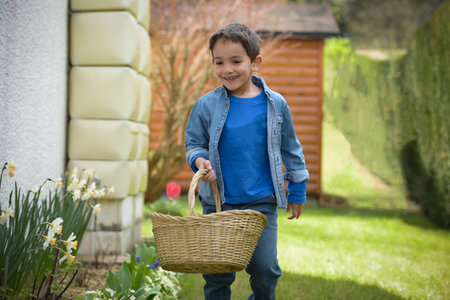 view on a young boy looking for easter eggs in the garden at springの写真素材