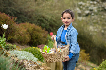 view on a young boy looking for easter eggs in the garden at springの写真素材