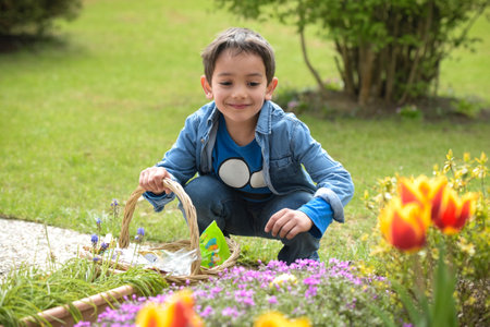 view on a young boy looking for easter eggs in the garden at springの写真素材
