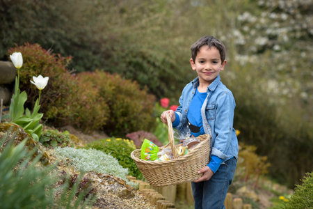 view on a young boy looking for easter eggs in the garden at springの写真素材