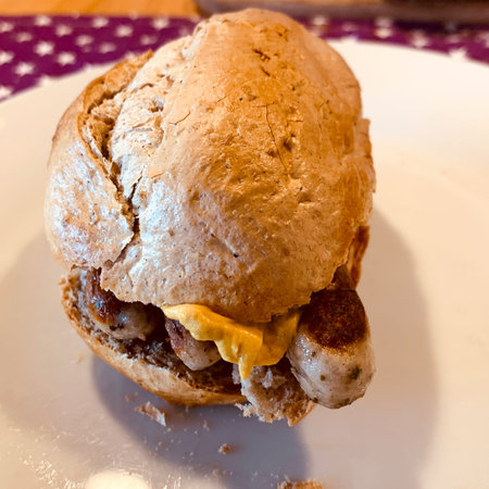 Three Nuremberg grilled sausages with mustard in a bunの写真素材