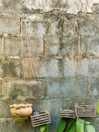Old concrete block wall with empty hanging flower potsの写真素材