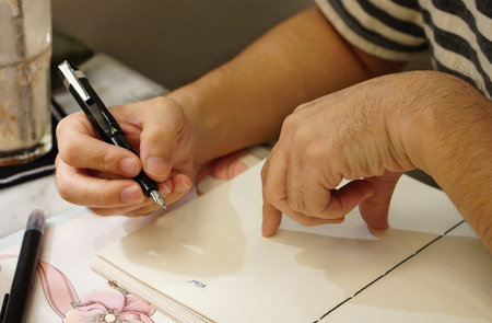 a man writing on the blank notebookの写真素材