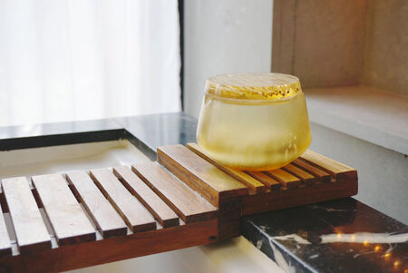 body scrub in translucent natural bowl on the timber railの写真素材