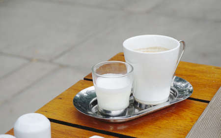 Coffee with milk on stainless steel plateの写真素材
