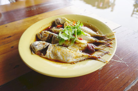 mackerel cook with special sauce on yellow plates