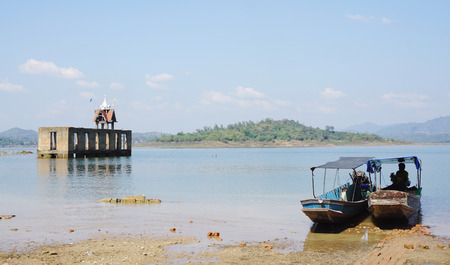 Thai temple ruins in the lake with boatsの写真素材