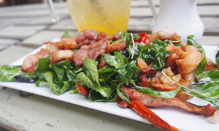 Fried pork with cripy thyme and chili with plum juice and flower pot backgroundの写真素材