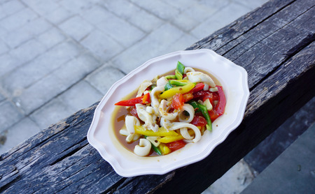 Stir fried squid with salted egg and pepper in white plateの写真素材
